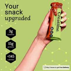 Hand holding a Creatime protein bar with nutritional information on a green background